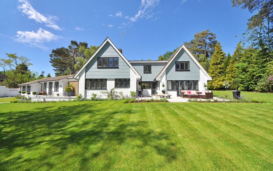 Stock photo of a neatly mowed green lawn in front of a landscaped home