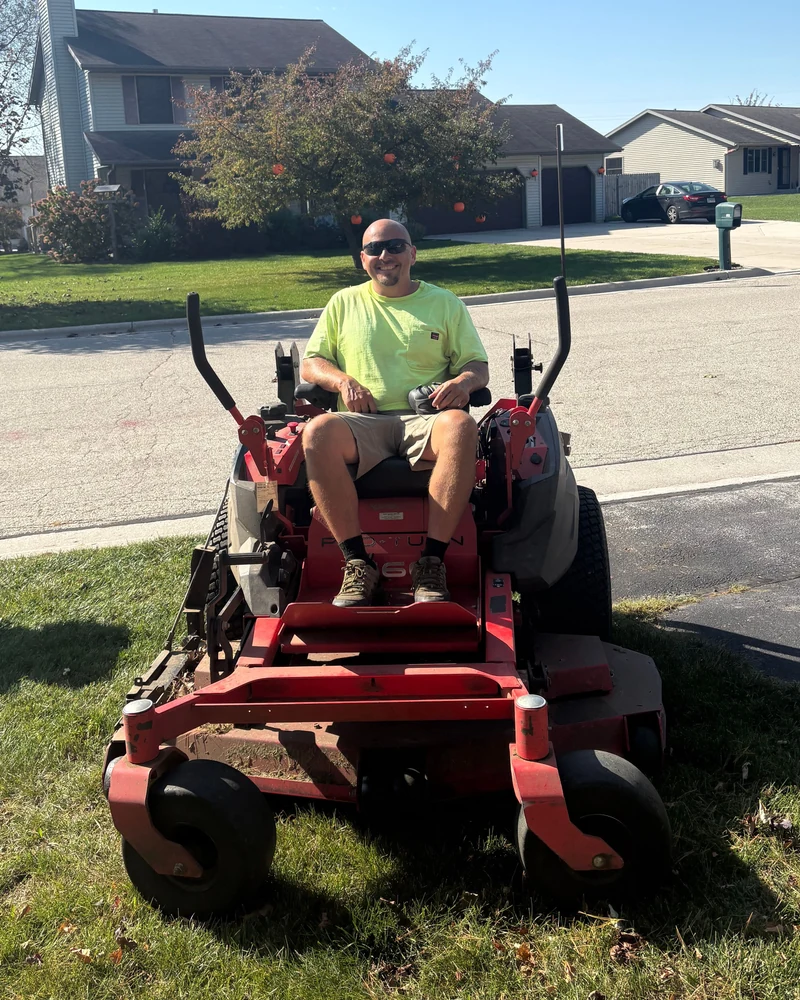 Joe Lengling, owner of Lengling Property Management, seated on a riding lawn mower